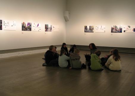 Lapsia istumassa ringissä näyttelytilan lattialla. 