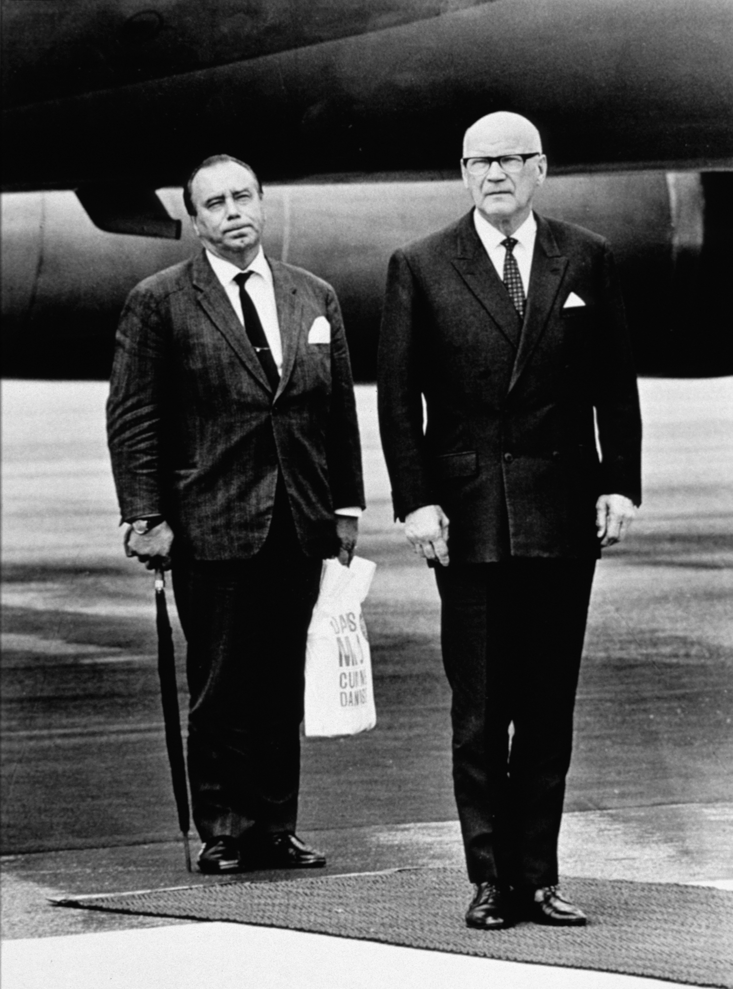 Presidentti Kekkosen ryhdikkyys ja arvovalta luo tragikoomisen kontrastin ulkoministeri Väinö Leskisen arkisen muovikassin värittämään habitukseen. Muovikassi sai irvailevan merkityksen, kun se yhdistettiin Leskisen alkoholiongelmaan. Martti Peltonen: Muovikassi, 1970. Vuoden lehtikuva 1970. D2007:67/v1/139