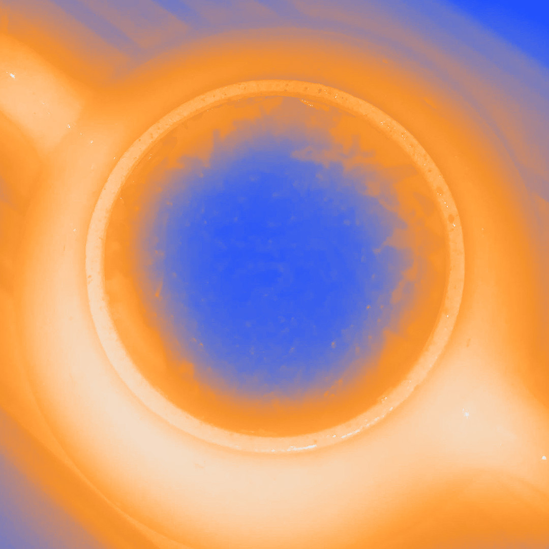 Abstrakti kuva, jonka keskellä on ympyrä ja sävyt oranssia ja sinistä.