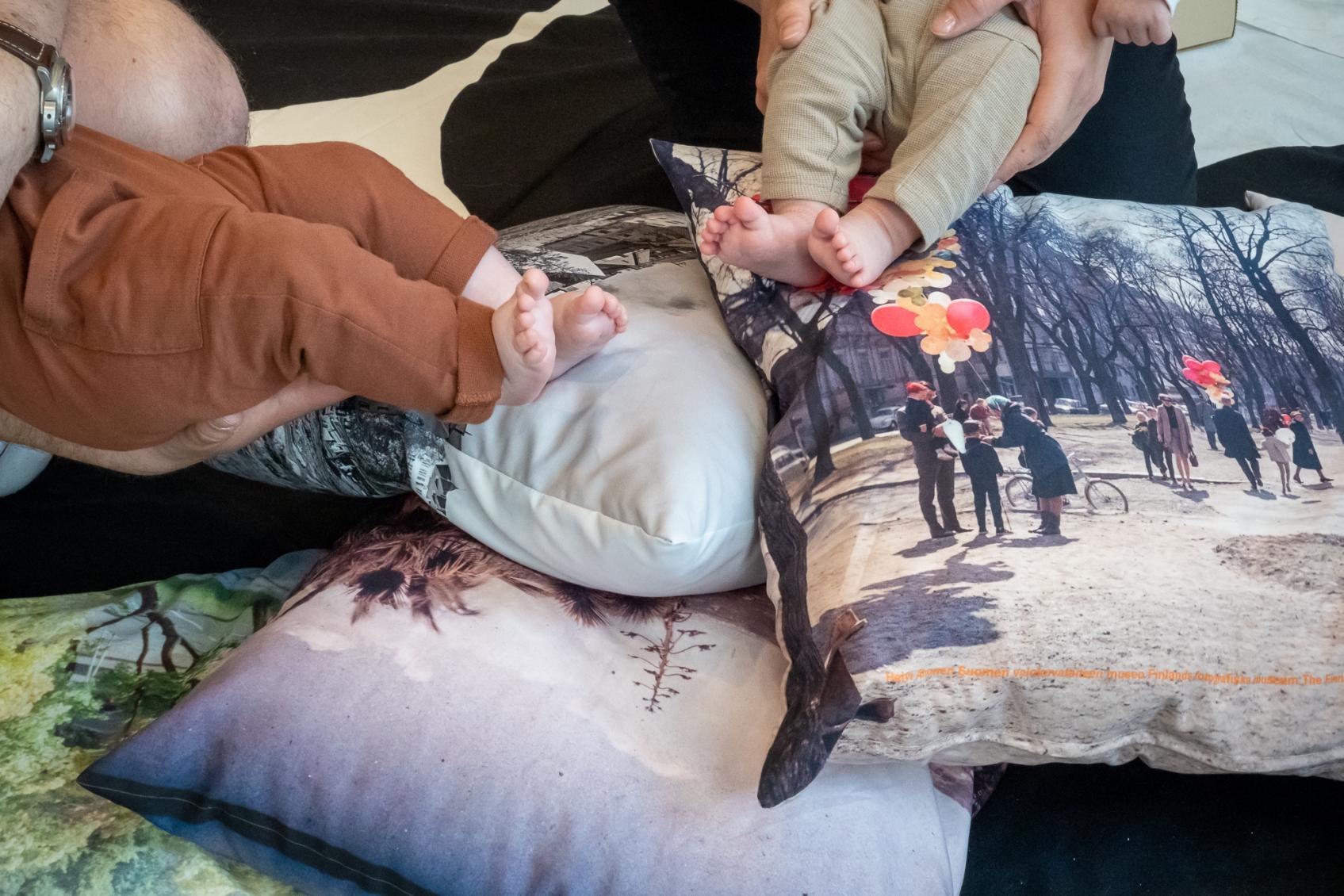 Pienten vauvojen paljaat jalkapohjat näkyvät valokuvatyynyjen keskellä.