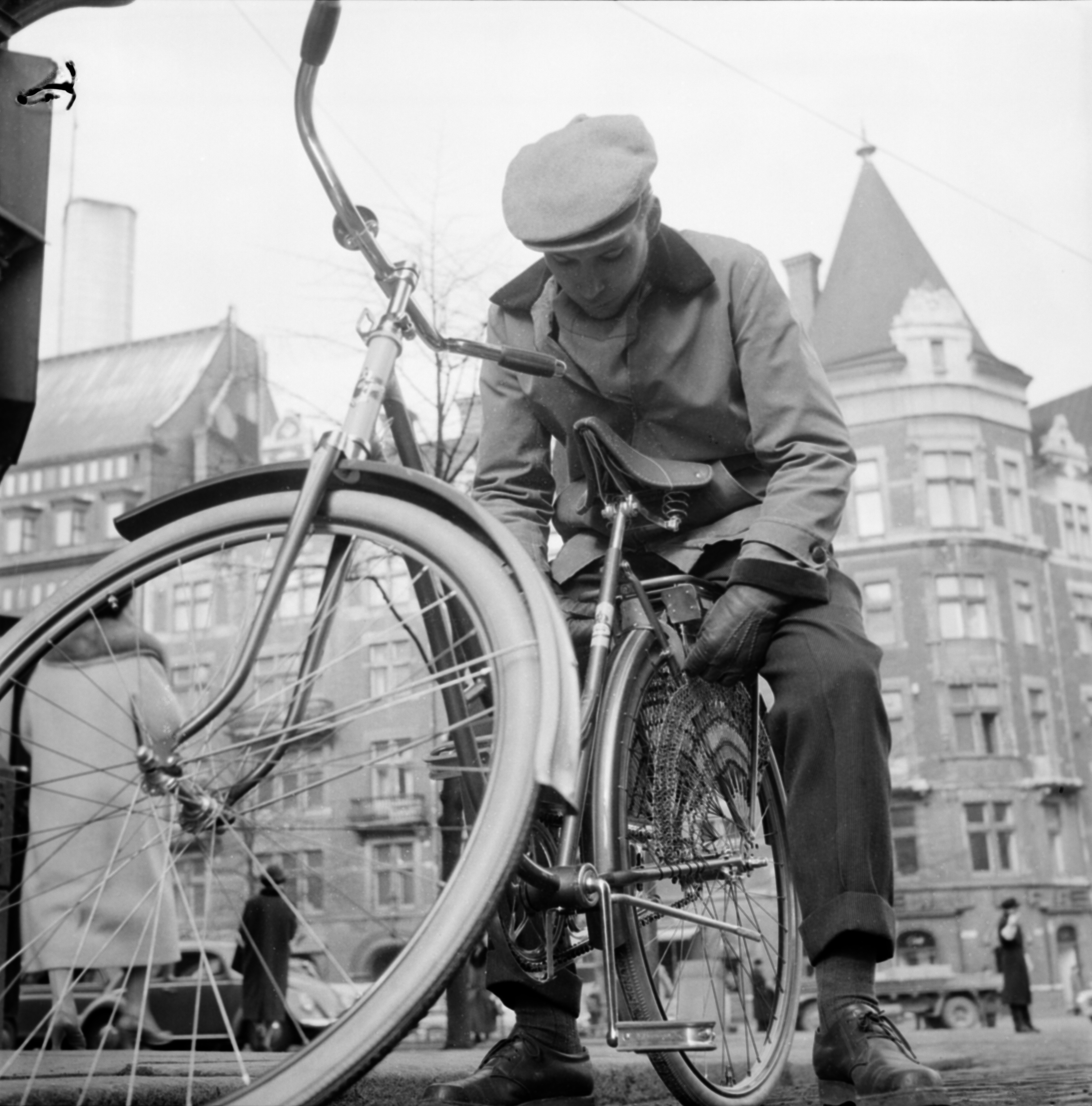  Nuori mies esittelee polkupyöränsä lukkoa Mannerheimintiellä, takana Wulffin kulma. Helsinki, 1958. Suomen valokuvataiteen museo/ Uuden Suomen kokoelma.