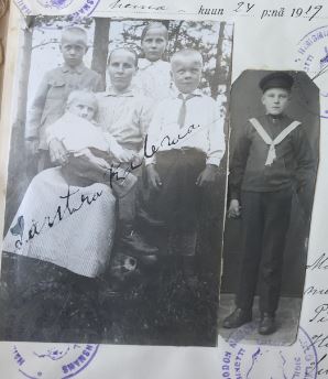 Mustavalkoinen kuva jossa on ilmeisesti äiti ja neljä lasta. Kuvan vieressä on toinen mustavalkoinen kuva, jossa on yksi poika. Osittain kuvien päällä on leimoja, ja isomman kuvan päälle on kirjoitettu käsin jotain. Kuvien yläpuolella lukee heinäkuun 24 päivänä 1917.