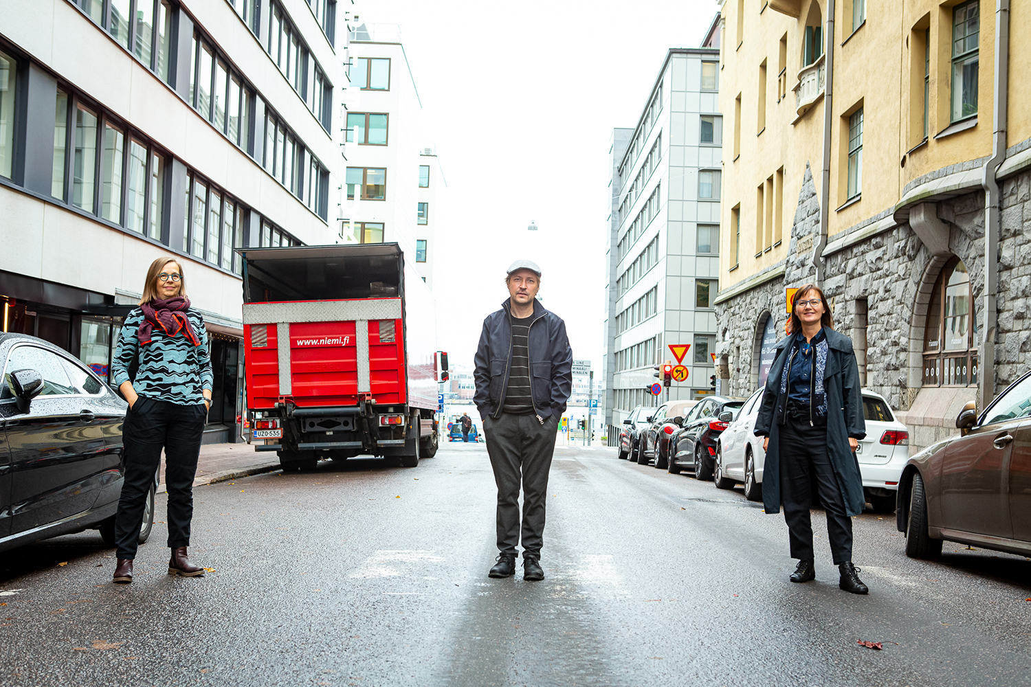 Kolme henkilöä seisoo kadulla parin metrin etäisyydellä toisistaan. Vasemmassa reunassa on museonjohtaja Elina Heikka, keskellä taiteilija Jari Silomäki ja oikealla podcastin juontaja Erja Salo. 