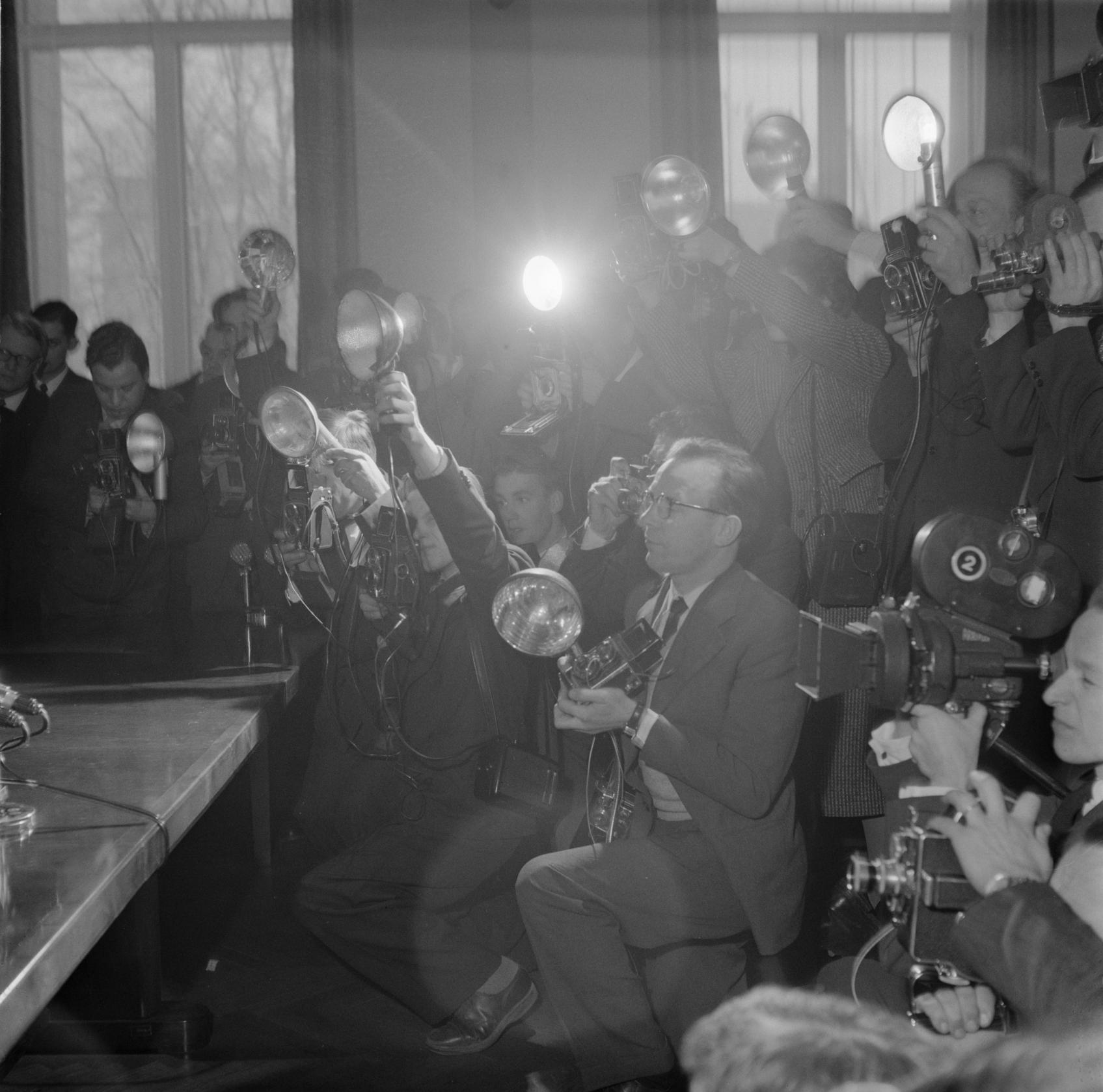 Lehtikuvaajia ja tv-kuvaajia uutisoimassa Porkkalan luovutusta. Kuva on otettu todennäköisesti tammikuussa 1956 Porkkalan luovutusjuhlallisuuksien lomassa. K-G Roos, Suomen valokuvataiteen museon kokoelmat.