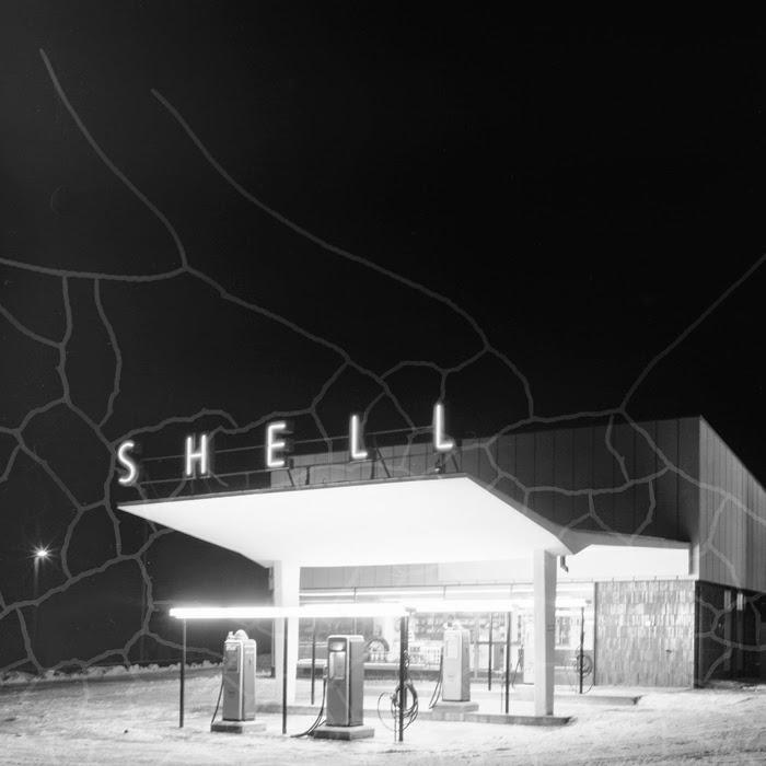 Yksityiskohta Kalle Hirnin ottamasta kuvasta yöllisestä Shellistä vuodelta 1957. Negatiivin näkyvät vauriot saavat Shellin huoltoaseman lähes ‘salamoimaan’