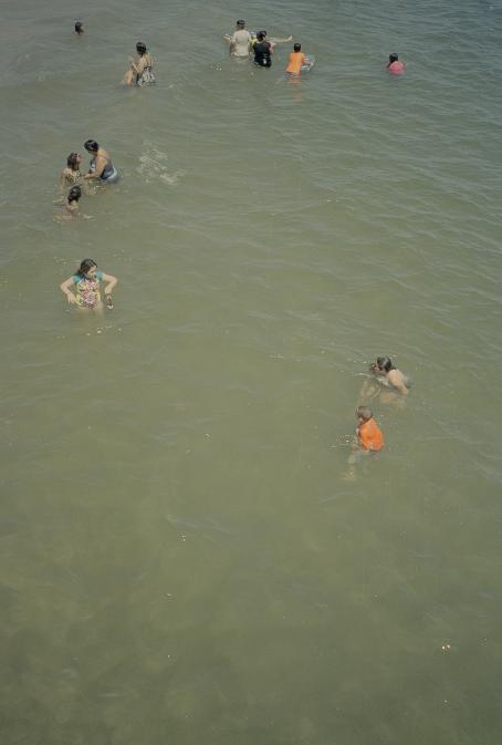 Ylhäältäpäin otettu kuva, jossa näkyy vain vettä ja vedessä olevia uimareita.