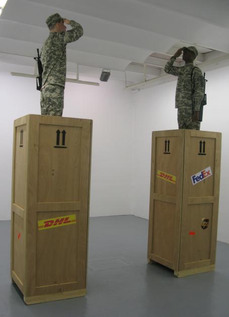 Kaksi korkeaa puista laatikkoa, joiden molempien päällä seisovat sotilaat toisiaan katsoen.