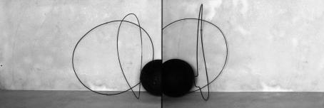 Vierekkäin kaksi kuvaa, joissa harmaata taustaa vasten mustista viivoista koostuvia muotoja ja reunassa musta pallo. 