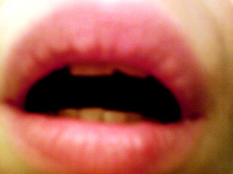 Epätarkka lähikuva ihmisen suusta, joka on vähän auki ja hampaat näkyvät hieman.