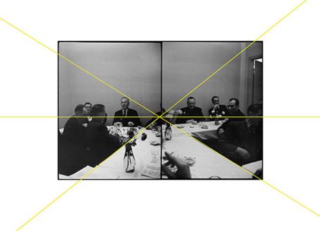 Vierekkäin kaksi mustavalkoista kuvaa, joissa istuu miehiä pöydän ääressä. Kuvien läpi on vedetty suoria keltaisia viivoja, jotka kohtaavat suunnilleen kuvien keskellä.
