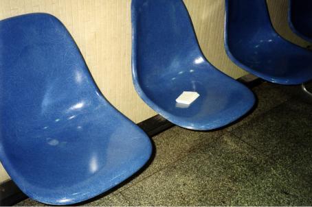 Rivissä muovisia sinisiä tuoleja. Yhdellä tuoleista on taiteltu nenäliina. 