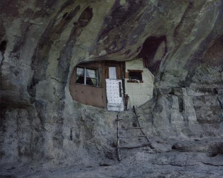 Kalliossa olevaan reikään tai luolaan on tehty seinä, ikkuna ja ovi. Ovelle menevät lyhyet tikkaat.