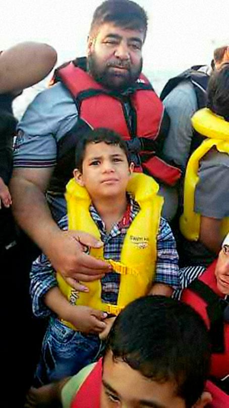 Mies ja poika. Miehellä on punainen pelastusliivi ja pojalla keltainen. Mies pitää kättään pojan rinnalla. Kuvassa näkyy myös osittain muita ihmisiä joilla on pelastusliivit.