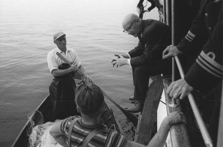 Urho Kekkonen keskustelee nuottaa näytösluonteisesti vetäneiden miesten kanssa ja tarjoaa heille sikarit. Kalle Kultala, Savonlinna, 1961. Suomen valokuvataiteen museo.