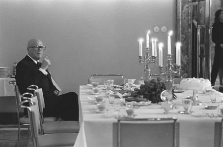 Eduskunnan työkauden avajaiset. Kansanedustajien kahvitilaisuus, presidentti Urho Kekkonen istuu kahvipöydässä yksin ja kutsuu tarjoilijaa.Kalle Kultala, Helsinki, 1976. Suomen valokuvataiteen museo.