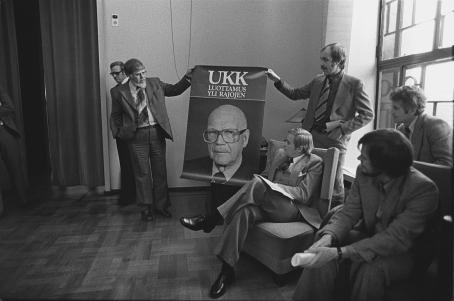 Presidentti Urho Kekkosen vaalikampanja. Vaalijulistetta esitellään eduskuntatalossa, RKP:n puoluesihteeri Bengt Bergman, päätoimittaja Pauli Myllymäki, puoluesihteeri Ulf Sundqvist ja puoluesihteeri Jorma Hentilä. Kalle Kultala, Helsinki, 1977?. Suomen valokuvataiteen museo.