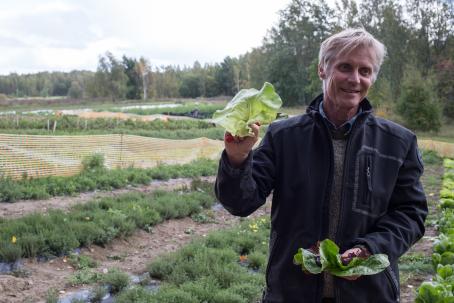 Steven Lowndes esittelee pellolla kasvavia salaattilajikkeita. Kuva: Virve Laustela, Suomen valokuvataiteen museo