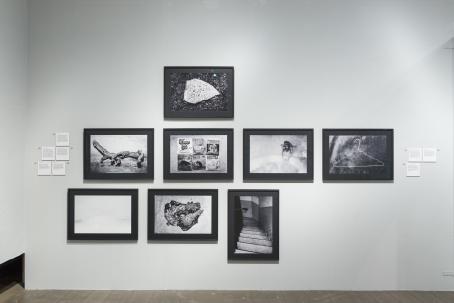 Näyttelytilassa seinällä mustavalkoisia kehystettyjä kuvia. 