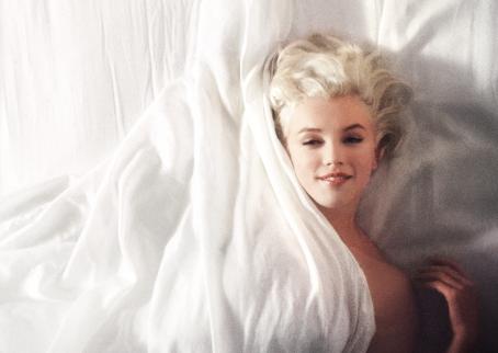 Marilyn Monroe makaa valkoisissa silkkilakanoissa. Kuva on utuinen ja hieman rakeinen. Monroe hymyilee ja katsoo suoraan kameraan. Lakana peittää hänet kaulaan asti, mutta toinen olkapää ja käsi näkyvät paljaina.