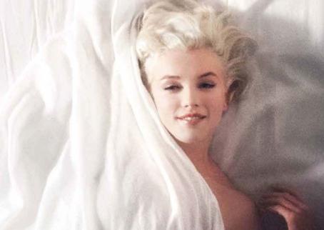 Marilyn Monroe makaa valkoisissa silkkilakanoissa. Kuva on utuinen ja hieman rakeinen. Monroe hymyilee ja katsoo suoraan kameraan. Lakana peittää hänet kaulaan asti, mutta toinen olkapää ja käsi näkyvät paljaina.