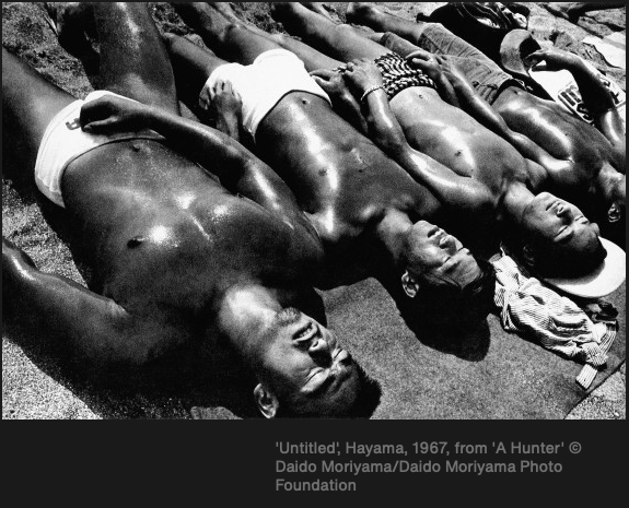 Mustavalkoinen kuva, jossa henkilöitä makaa maassa.